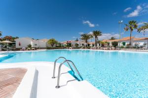 ein großer Pool in einem Resort mit Palmen in der Unterkunft Bungalow Angelika Campo Golf in San Bartolomé de Tirajana