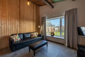 a living room with a couch and a large window at Welcome in - Appartementen Pleinzicht, met zonnige balkon I Dorpsplein 6 Koudekerke in Koudekerke