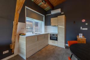 a small kitchen with a sink and a window at Welcome in - Appartementen Pleinzicht, met zonnige balkon I Dorpsplein 6 Koudekerke in Koudekerke