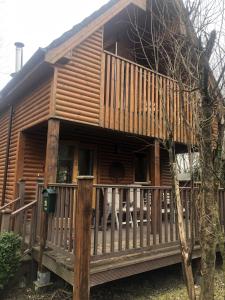 a log cabin with a porch and a fence at Cat's Cabin by the River in Belturbet