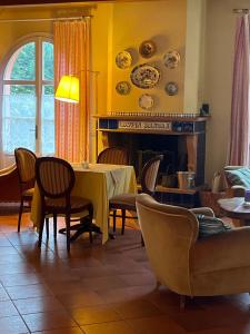 a dining room with a table and chairs and a fireplace at Villa Solarola Country House in Castel Guelfo di Bologna