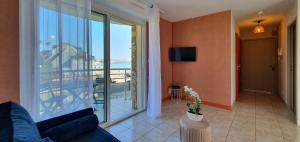 ein Wohnzimmer mit Couch und großem Fenster in der Unterkunft la perle de lecume in Quiberon