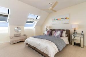 a bedroom with a bed and a ceiling fan at Dolphin Beach Penthouse in Cape Town +26 photos