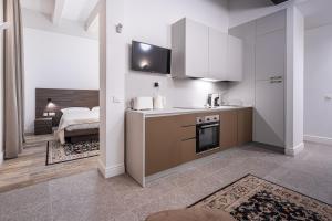 a kitchen with white cabinets and a bed in a room at Old Theatre Suites - Tremiti in Valletta +14 photos