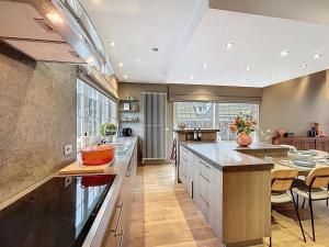 a large kitchen with a large island and a table at Villa Charme - Koksijde in Koksijde