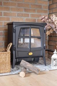 a black stove sitting next to a brick wall at Charming cottage with hot tub & private garden in Rochester
