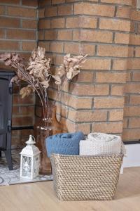 a vase and baskets on a table with a brick wall at Charming cottage with hot tub & private garden in Rochester