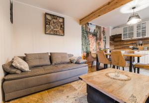 a living room with a couch and a table at Słoneczna Wetlina - Apartament 2 z kominkiem in Wetlina +9 photos