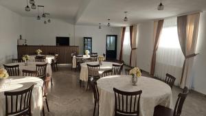 a dining room with tables and chairs with flowers on them at Casa 1 Mai in Curtea de Argeş