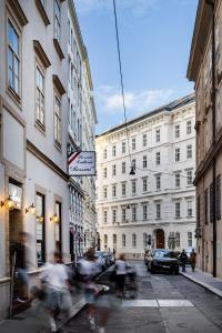 een groep mensen die door een straat met gebouwen lopen bij Wilde Vienna Fleischmarkt in Wenen