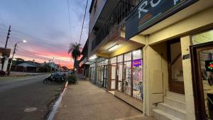 a building on the side of a street with a motorcycle parked outside at Pequeño Monoambiente Céntrico IGR 1D in Puerto Iguazú