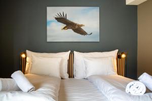 a bedroom with two beds with a bird flying overhead at Nordis Hotel Lofoten in Svolvær