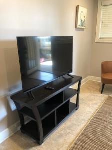 TV de pantalla plana grande en un centro de entretenimiento negro en 2 br washer dryer Near LSU Tiger Stadium, en Baton Rouge