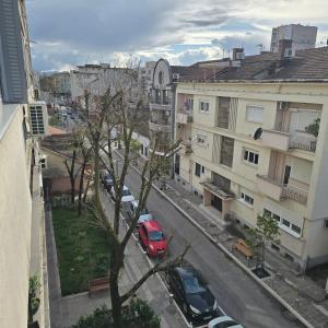 a red car parked on a city street with buildings at Rosewood Podgorica in Podgorica