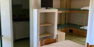 Una habitación con dos literas y un televisor. en serra alimini 2, en Otranto