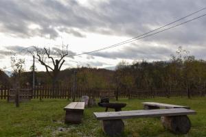 two wooden benches in a field with a fence at Arktik in Bojnice