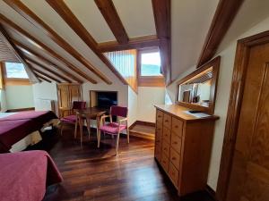 ein Schlafzimmer mit zwei Betten, einem Tisch und einem Spiegel in der Unterkunft Hotel Aragüells in Benasque + 97 Fotos
