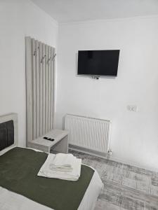 a bedroom with a bed and a flat screen tv at Casa 1 Mai in Curtea de Argeş