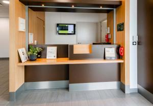 a reception desk in a hospital lobby with a phone at B&B HOTEL Nantes Savenay in Savenay