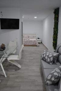 a living room with a couch and a glass table at Viviendas de Uso Turístico Noble Hidalgo TOLEDO in Toledo