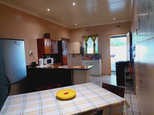 a kitchen with a table with a yellow plate on it at Suburbia in Rustenburg