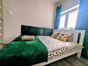 Un dormitorio con una cama con un edredón verde. en Apartament Zielony Krakowskie Przedmieście 26/2, en Lublin 1 foto más