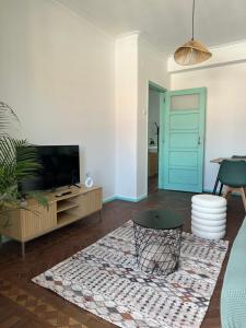 un salon avec une télévision et une table dans l'établissement Belém Apartment with Tagus River View, à Lisbonne