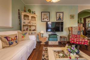 a living room with a white couch and a tv at Casa Rustica Ivano in Biograd na Moru