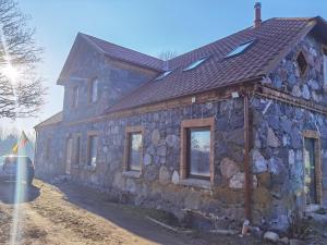 a stone house with a slate roof on the side at Laumės dvaras in Kruopinė