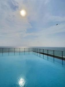 a swimming pool with the ocean in the background at Pearly Ocean View Suite in Dehiwala