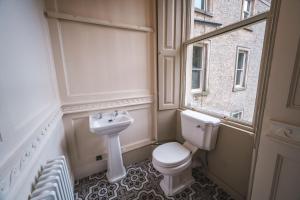 a bathroom with a toilet and a sink and a window at The Chapel Suite in Marske