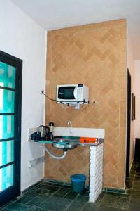 a microwave sitting on top of a wall in a room at Chalés Suítes Ubatuba Paradise Toninhas in Ubatuba