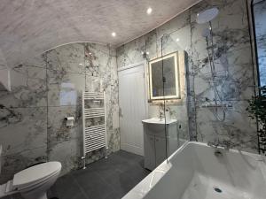 a bathroom with a tub and a toilet and a sink at Spaghetti House - 6 Bedroom Contractor House Sleeps 12 Parking for 3 Vans Bromford Duddeston Fort Dunlop Star City Saltley Viaduct HS2 in Birmingham +36 photos