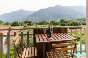 a wooden table and chairs on a balcony with mountains at IseoLakeRental - Bosco di Lago in Solto Collina