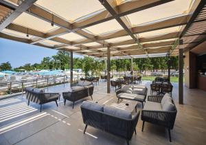 an outdoor patio with couches and tables and chairs at Camping Park Umag - Eurocamp I Homair in Umag