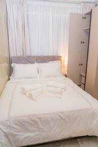 een wit bed met twee witte handdoeken erop bij KML Luxury Kinshasa-Gombe in Kinshasa