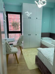 a bedroom with a bed and a chair and a dresser at Garden Building Luxury Apartment in Tirana +31 photos