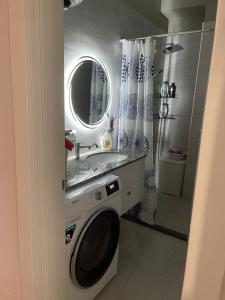a bathroom with a washing machine and a sink at Garden Building Luxury Apartment in Tirana