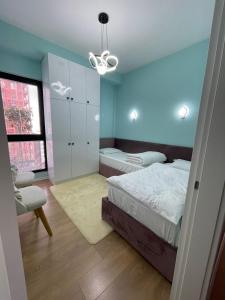 a bedroom with blue walls and a bed and a chair at Garden Building Luxury Apartment in Tirana