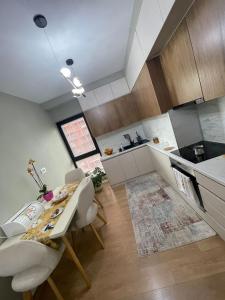 a kitchen with a table and chairs in a room at Garden Building Luxury Apartment in Tirana