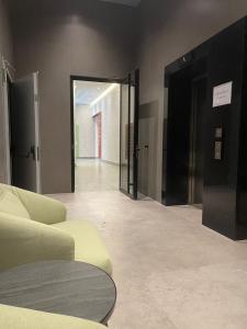 a living room with a couch and a glass door at Garden Building Luxury Apartment in Tirana
