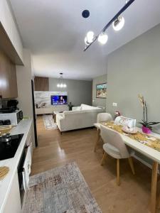 a kitchen and living room with a table and a couch at Garden Building Luxury Apartment in Tirana