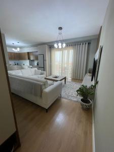 a living room with a white couch and a living room with at Garden Building Luxury Apartment in Tirana