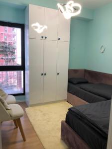 a bedroom with a bed and a white cabinet at Garden Building Luxury Apartment in Tirana