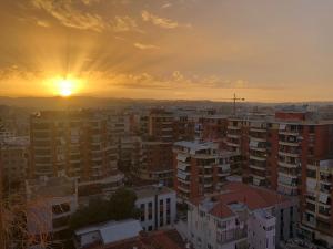 a city with the sun setting in the background at Garden Building Luxury Apartment in Tirana