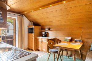 a kitchen with wooden walls and a wooden table and chairs at Ferienhaus Frühholz - Waxenstein in Grainau