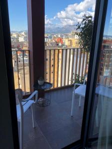 a balcony with two chairs and a table and a view at Garden Building Luxury Apartment in Tirana