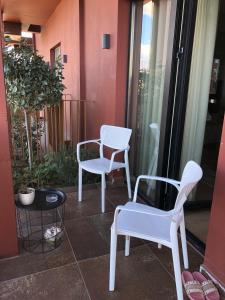 two white chairs and a table on a balcony at Garden Building Luxury Apartment in Tirana