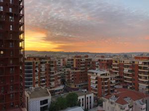 a view of a city at sunset with buildings at Garden Building Luxury Apartment in Tirana