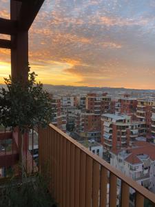 a view of a city at sunset from a balcony at Garden Building Luxury Apartment in Tirana
